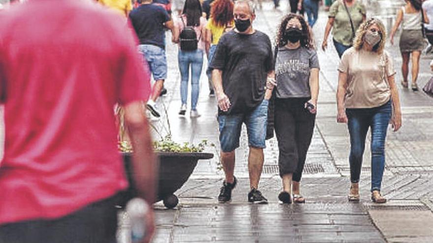 Personas paseando con mascarillas por la calle Castillo.