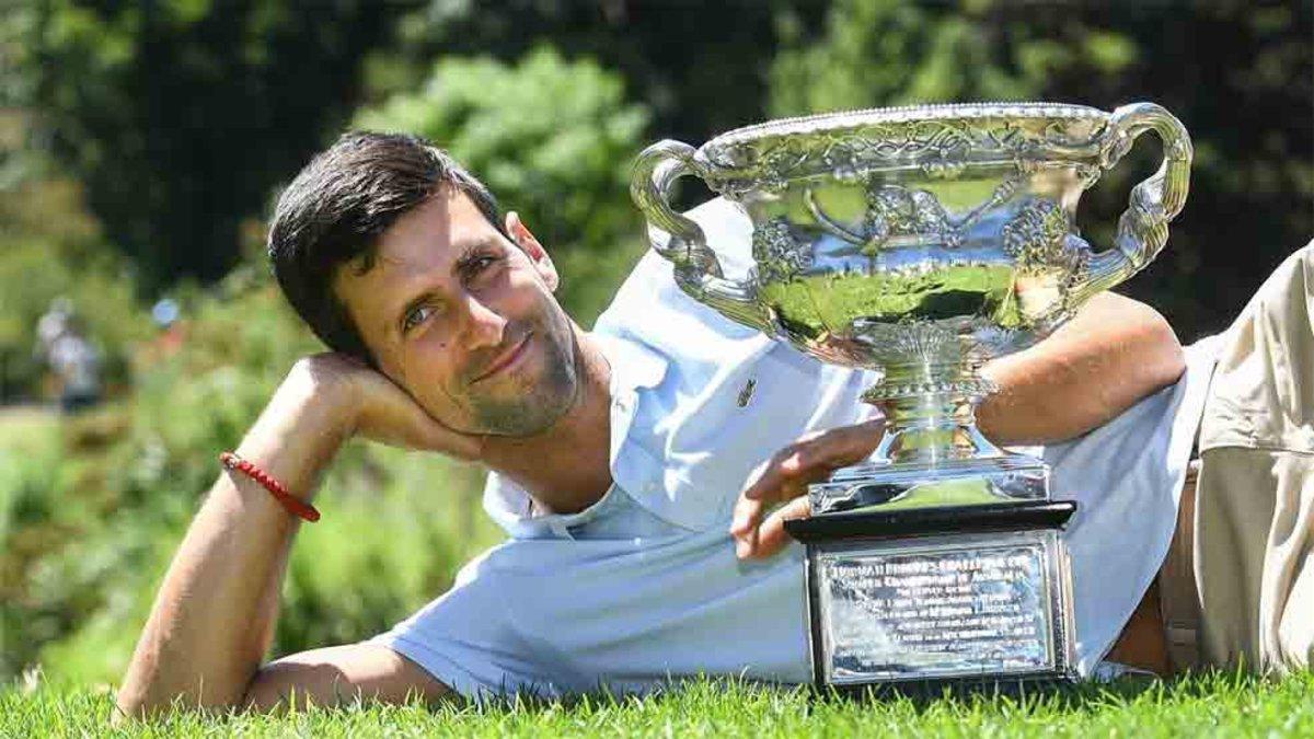 Novak Djokovic de Serbia posa para fotografiarse con el trofeo del campeonato en el Real Jardín Botánico de Melbourne.