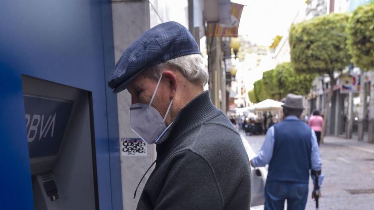 Un hombre saca dinero en un cajero automático. | |