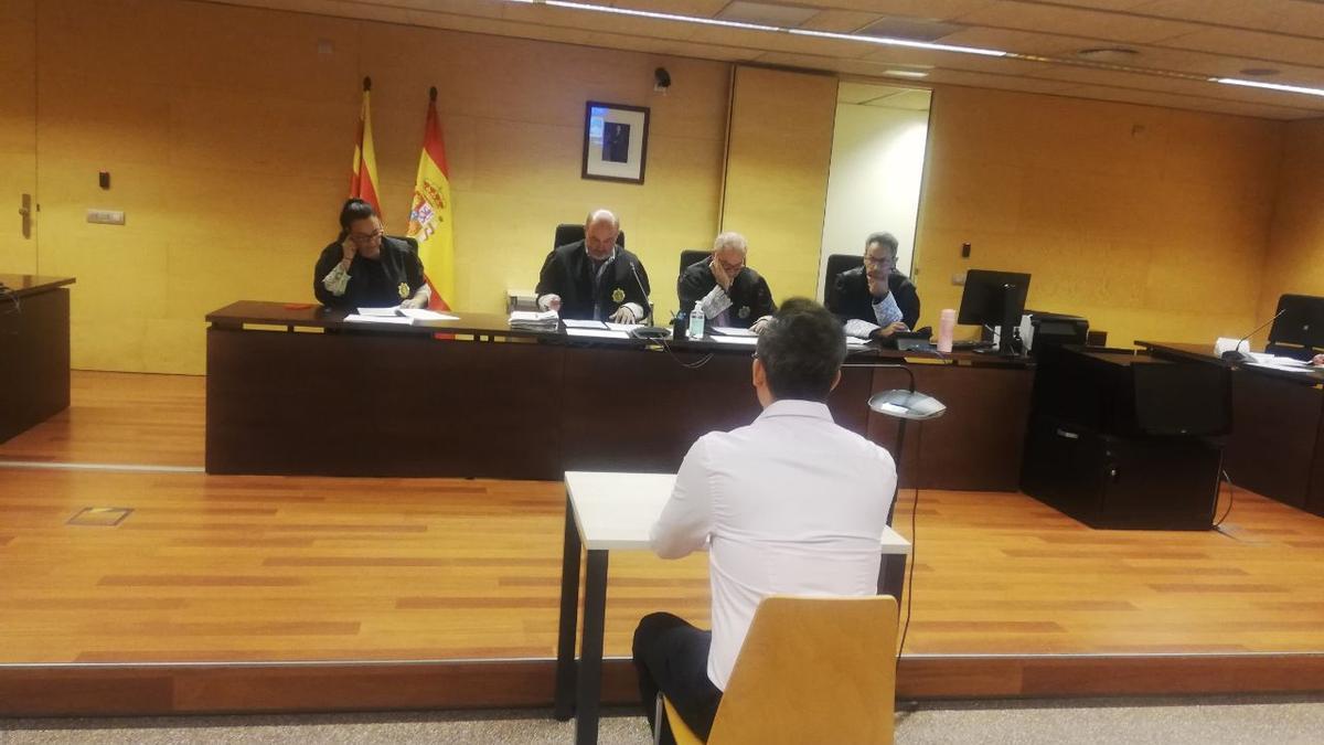 L'acusat, d'esquenes, durant la vista de conformitat a l'Audiència de Girona.