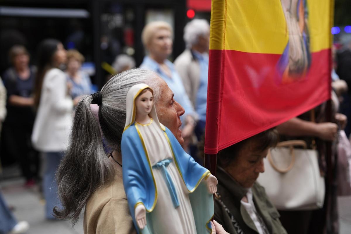 Una feligresa con una imagen de la virgen en el rezo del rosario de Ferraz (Madrid).