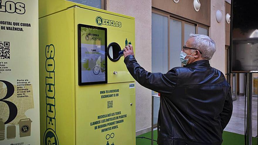 Joan Ribó tirando un envase en una máquina de Reciclos. | D. TORTAJADA