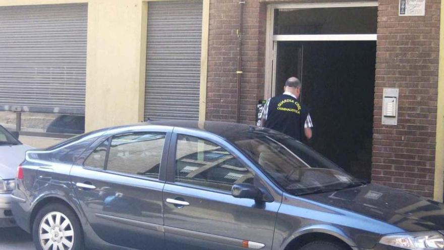 Un agente de la Guardia Civil toma fotografías del interior del edificio en el que tuvo lugar la agresión.