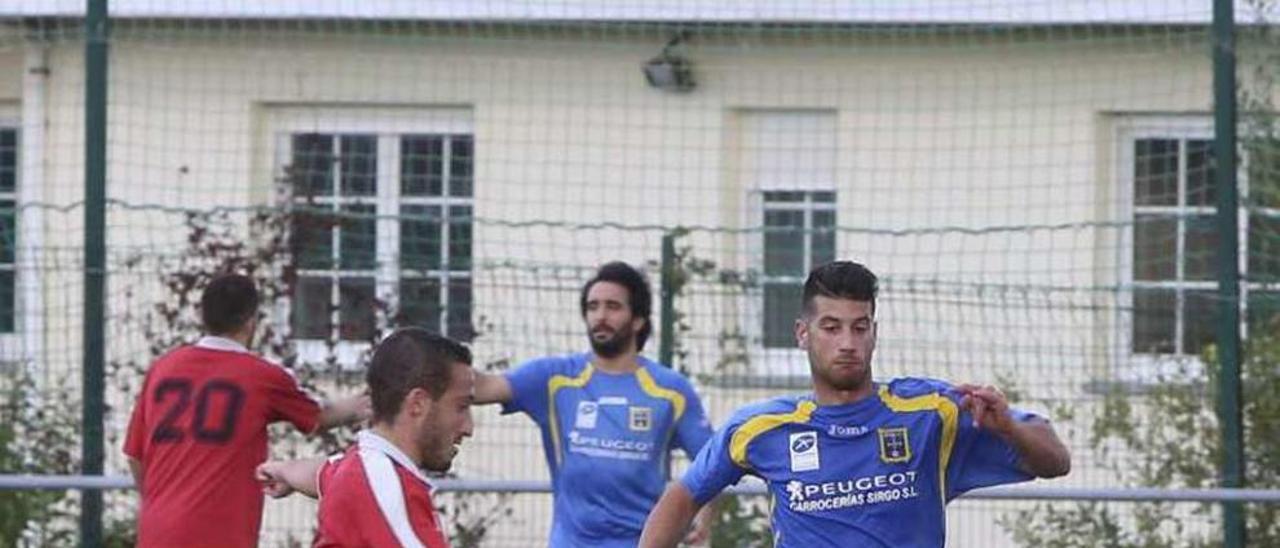 Dos jugadores del Bosco y el Gozón se disputan el balón.