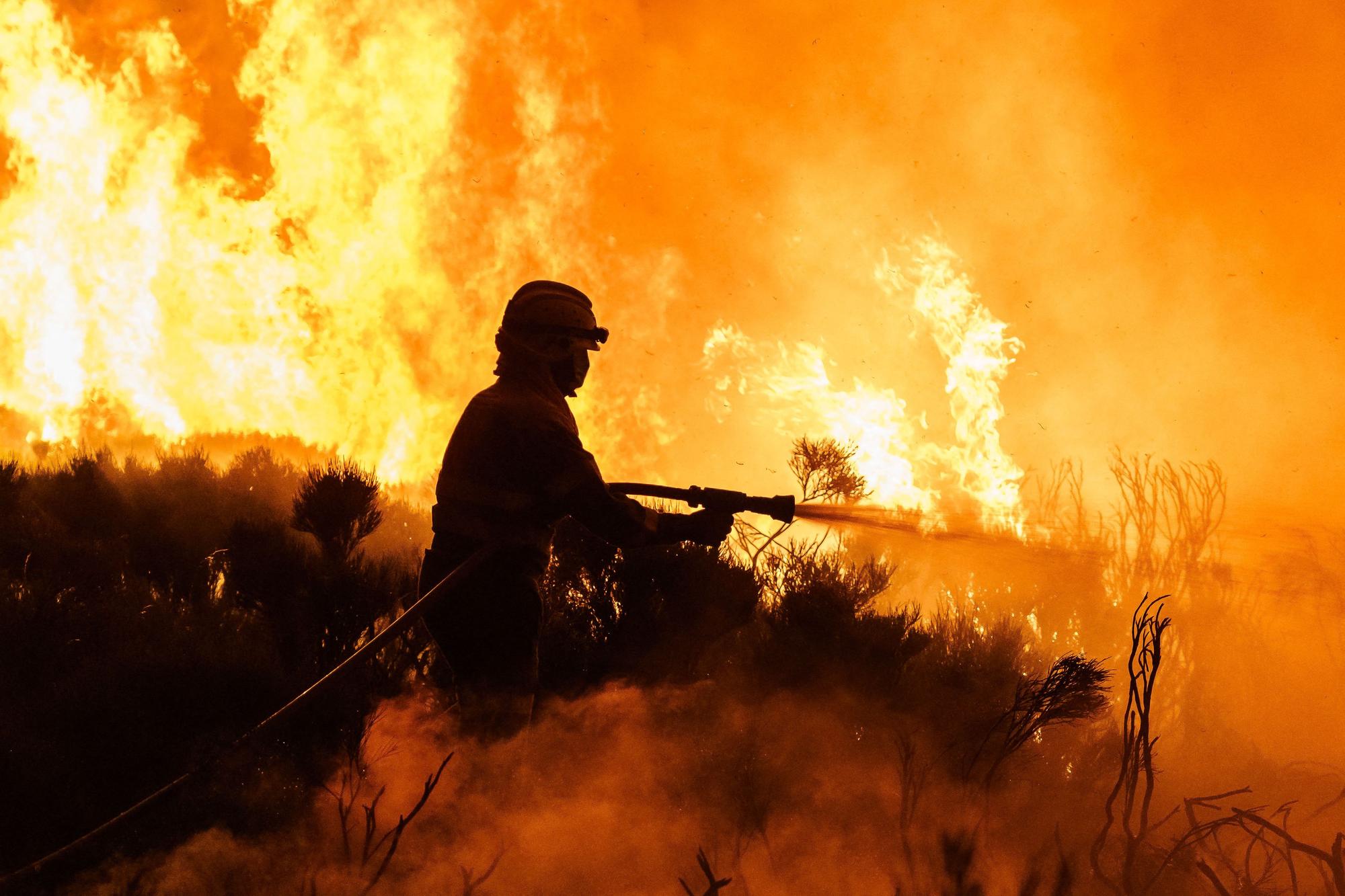 Un bombero trata de controlar un incendio.