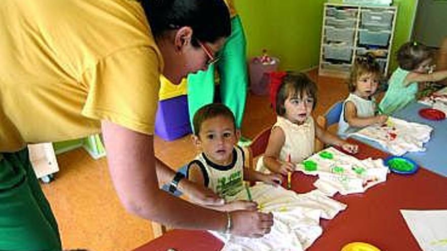 Una de las trabajadoras enseña a los niños a pintar en camisetas.