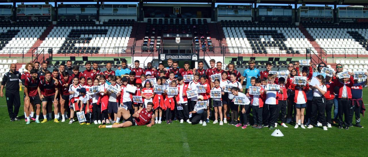 Los jugadores del Mérida con alumnos del CCEIP San Juan Bosco, que el jueves visitaron el entrenamiento.