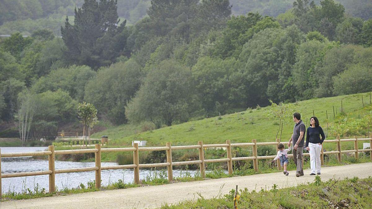 Una familia pasea por el entorno del embalse de Beche.