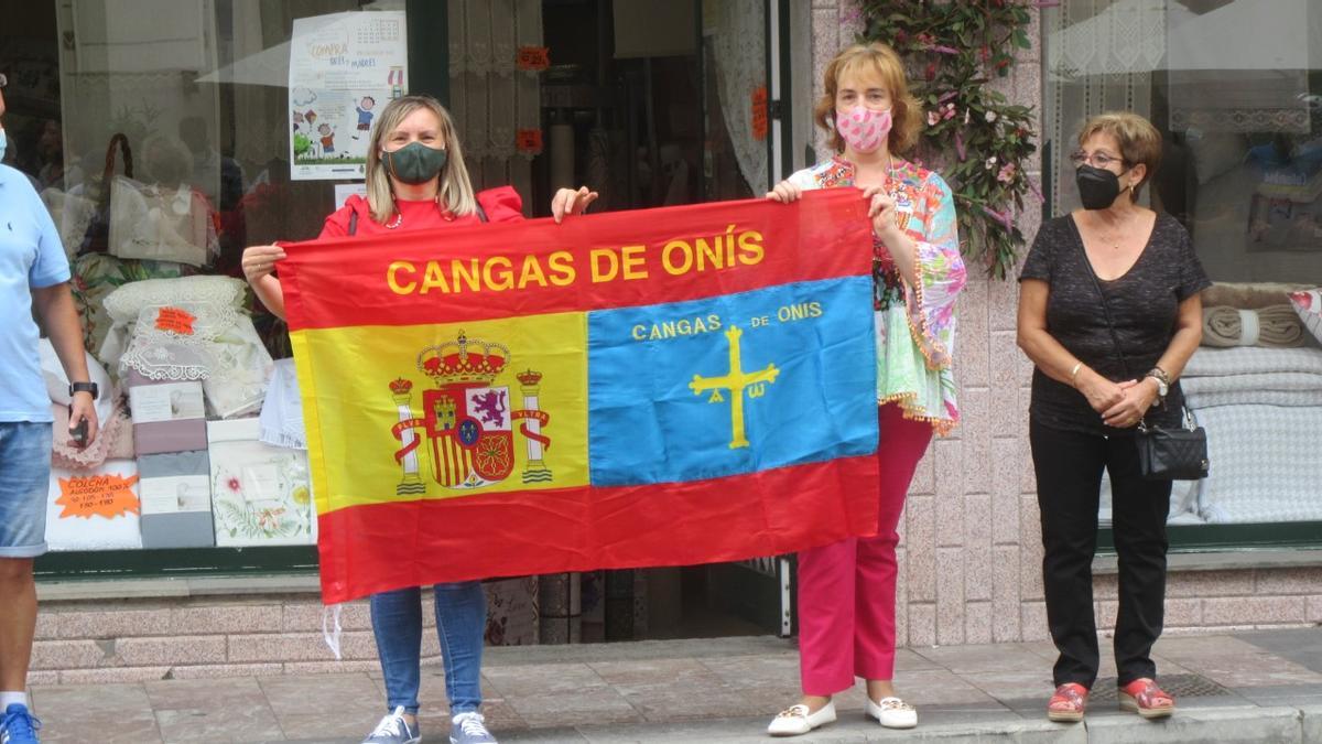 Unas seguidoras animan el paso de la Vuelta por Cangas de Onís con una significativa bandera.