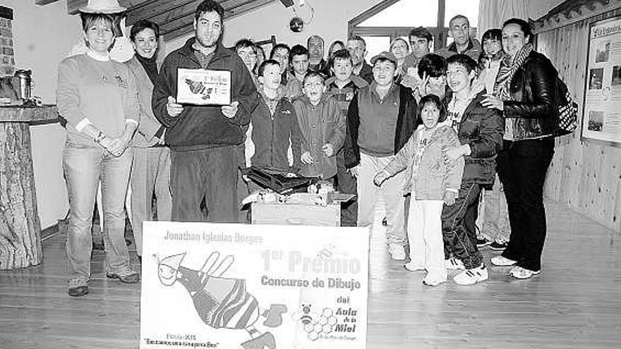 Jonathan Iglesias, con el certificado del premio, junto a otros participantes y autoridades locales, en el Aula de la Miel.