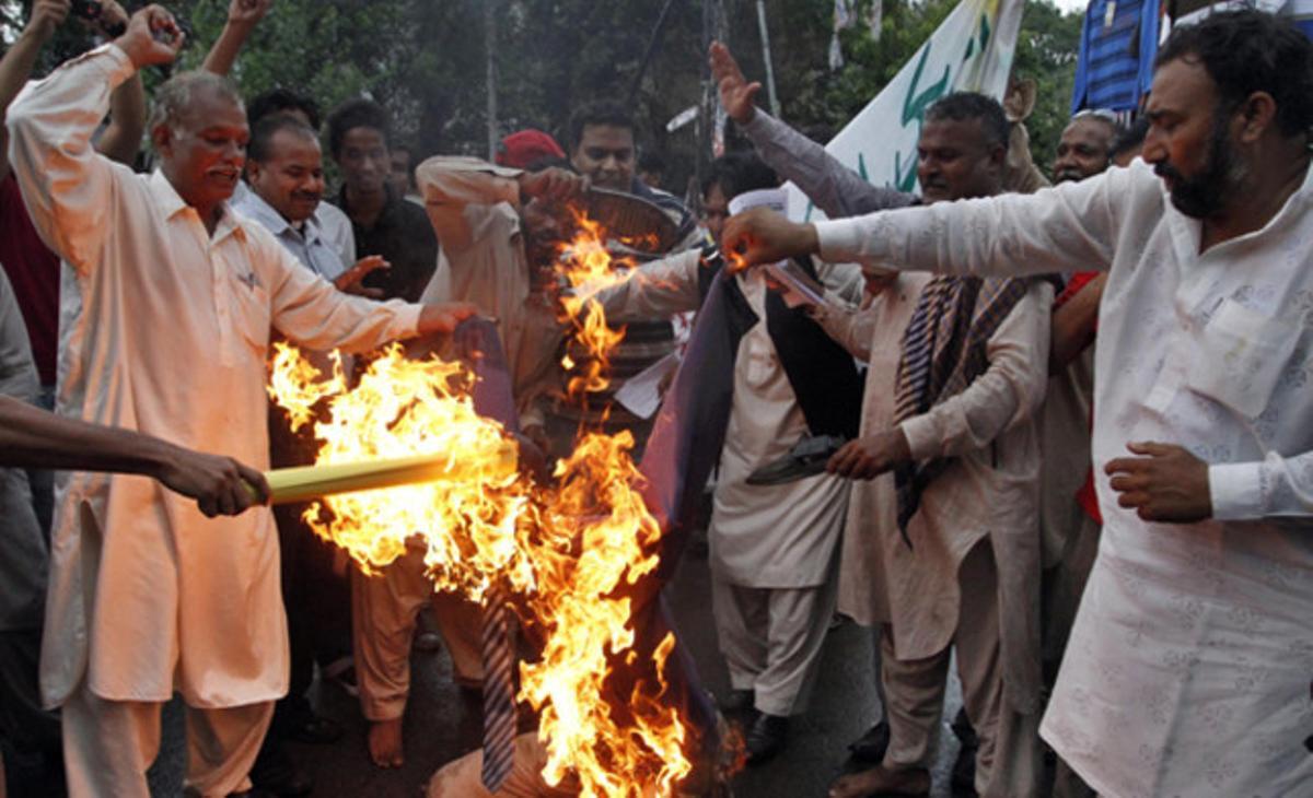 Cristians pakistanesos criden consignes mentre cremen l’efígie del pastor Terry Jones durant una protesta a Multan, al Pakistan.