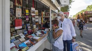 Archivo - Clientes y paseantes visitan la Feria del Libro de Madrid