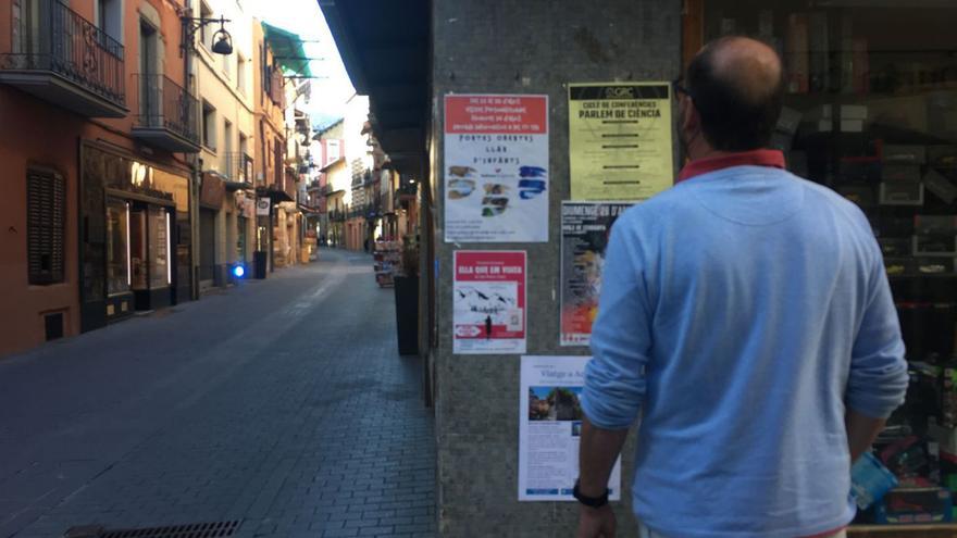 Un veí llegeix cartells en una de les parets tradicionals per aquesta acció a Puigcerdà | MIQUEL SPA