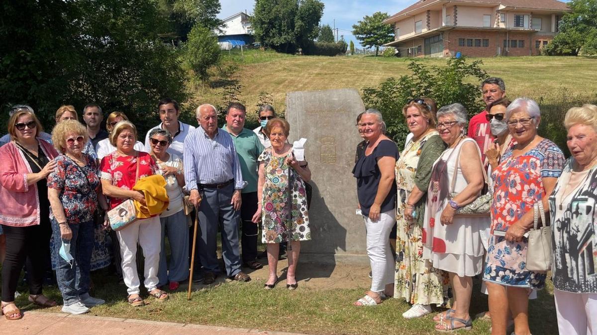 Tinina, en el centro de la imagen, junto al monolito que han puesto en su honor en el paseo que lleva su nombre, acompañada por representantes municipales y compañeras de la Asociación de Mujeres de Llanera. | A. L.