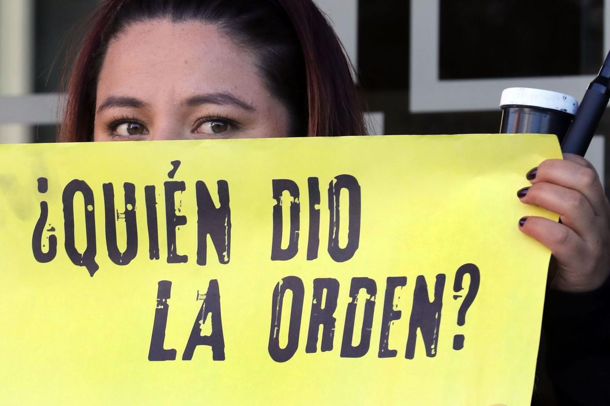 AME1628. BOGOTÁ (COLOMBIA), 12/02/2020.- Una mujer sostiene un cartel como símbolo de protesta, en la entrada del edificio de la Justicia Especial para la Paz (JEP) este miércoles en Bogotá (Colombia). Familiares de desaparecidos y asesinados extrajudicialmente conocidos como "falsos positivos", pidieron al ex comandante del ejército colombiano Mario Montoya, contar la verdad sobre los falsos positivos durante su audiencia ante la JEP. EFE/ Carlos Ortega