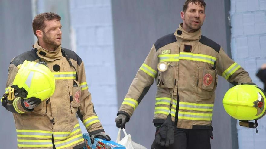 Dos bomberos recuperan un juego de Lego de un parque de bomberos de una vivienda del edificio incendiado de Campanar.