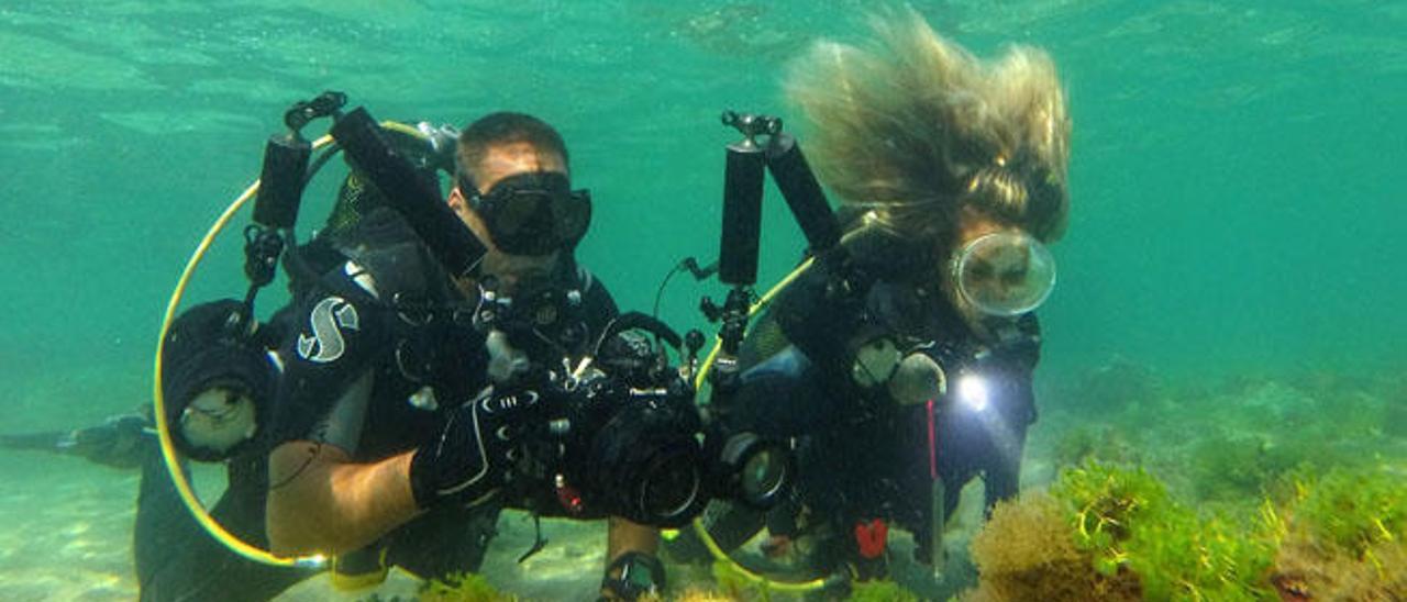 Dos profesionales tomando fotografías del fondo marino.