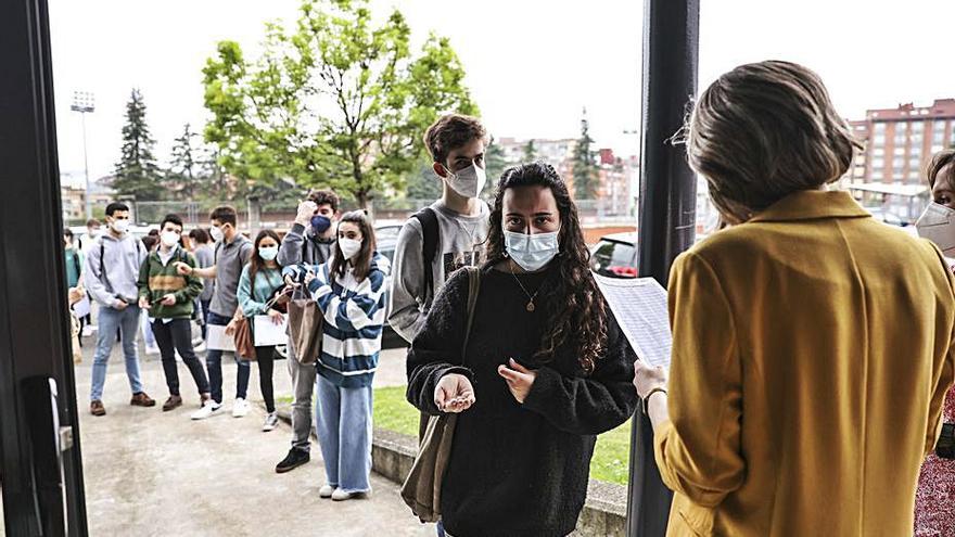 Un grupo de estudiantes acceden de uno en uno al polideportivo del CAU en Oviedo. | Irma Collín