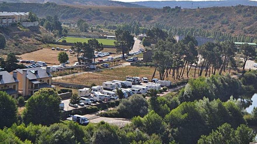 Caravanas aparcadas en la zona del Pinar de Puebla. Debajo, vertidos en el río Tera.