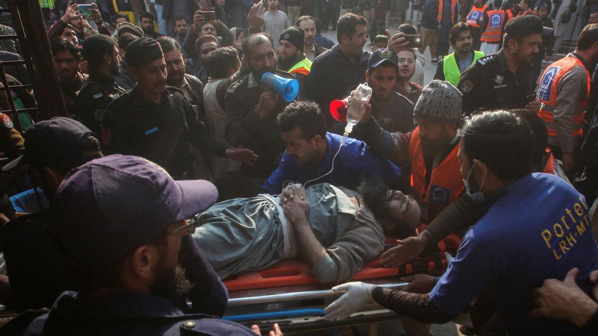 Voluntarios atendiendo a una víctima tras el atentado suicida a una mezquita en Peshawar