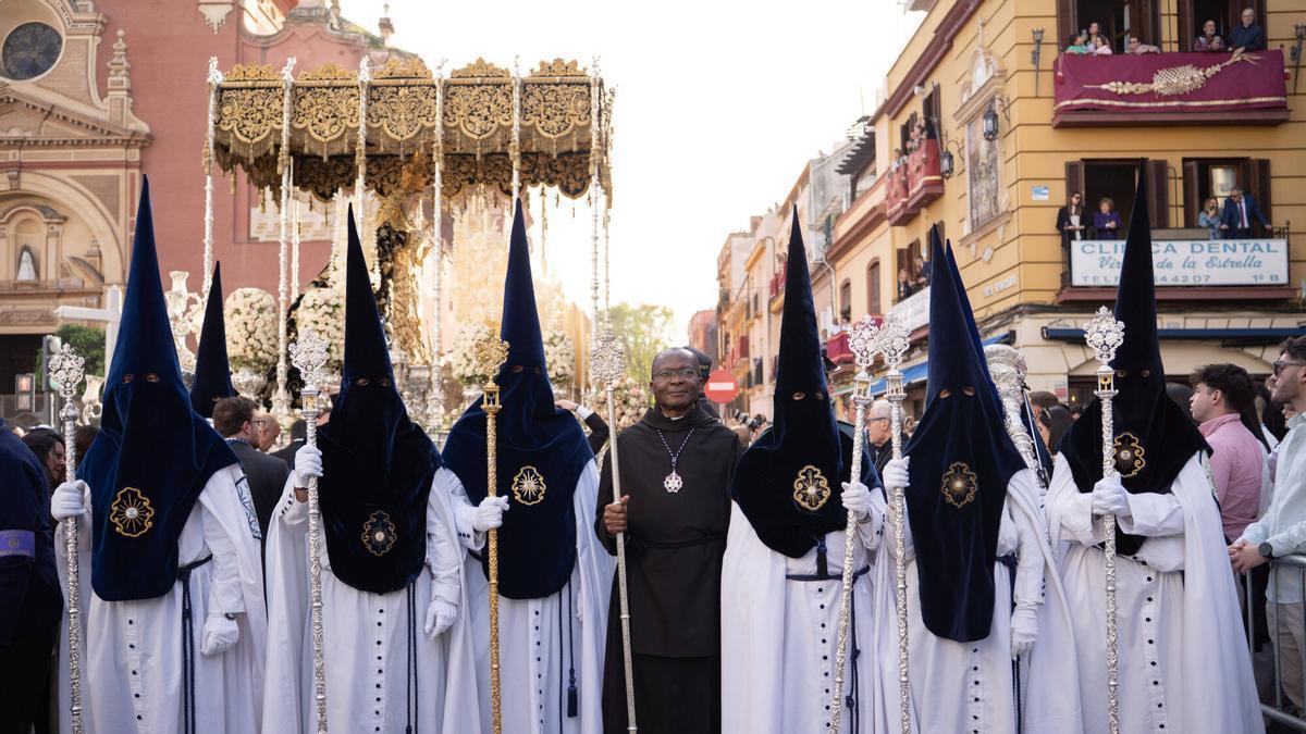 Nazarenos de la Hermandad de la Estrella junto al palio.