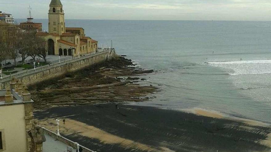 Parte del arenal, cubierto ayer por una mancha de carbón.