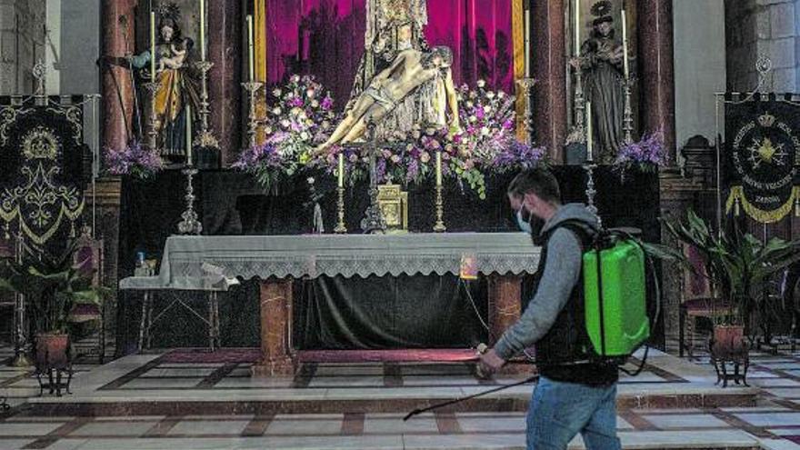 Un hombre desinfecta el altar de Nuestra Madre de las Angustias. | Emilio Fraile