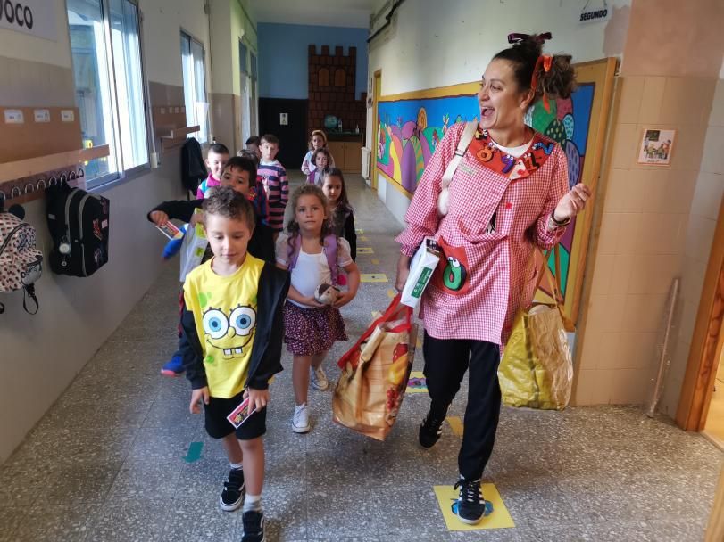 Una profesora, con su vestimenta de teatro, recibe a los niños en el colegio de A Torre de Cela.   | SANTOS ÁLVAREZ