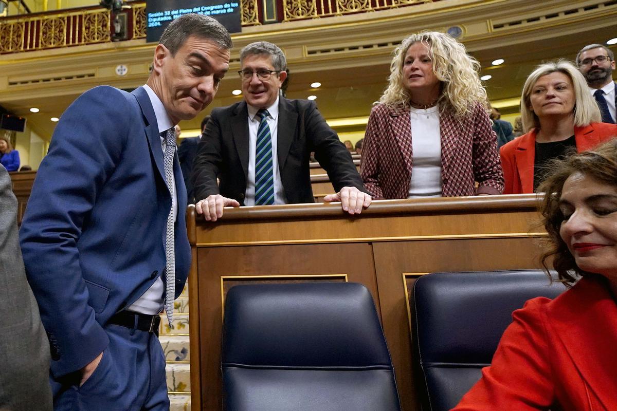 El presidente del Gobierno, Pedro Sánchez, acude a su escaño en el Congreso, junto al portavoz del grupo socialista, Patxi López, durante una sesión de control.