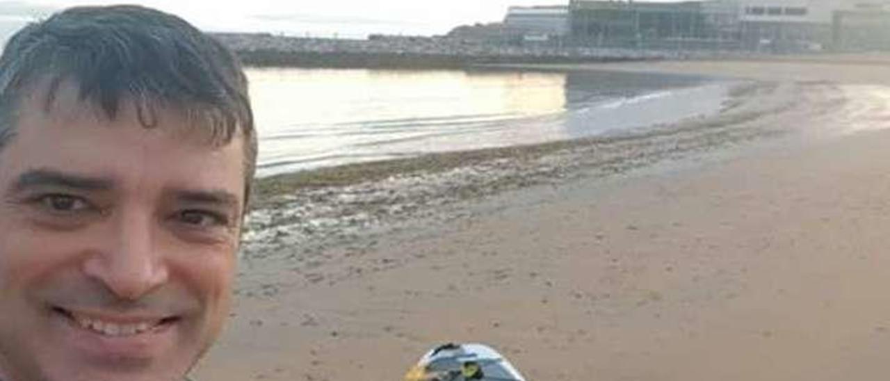 Juan Carlos Campo, junto a su tabla, tras realizar la travesía de paddle surf.