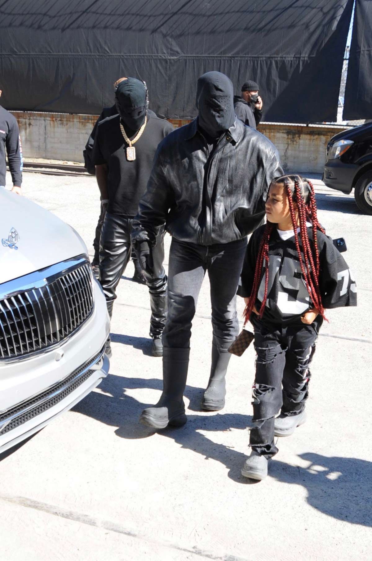 Kanye West, con la cara cubierta y su hija North llegan al estadio