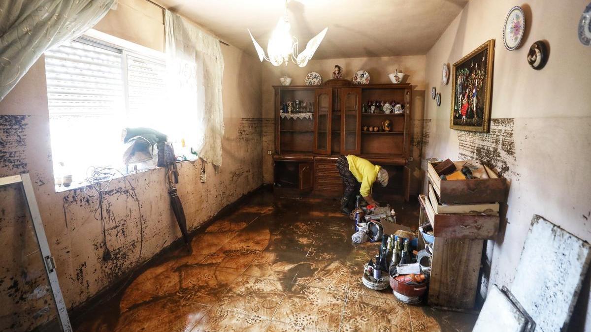 Una mujer recoge enseres en su casa un día después de las inundaciones en La Roca de la Sierra, el pasado mes de diciembre.