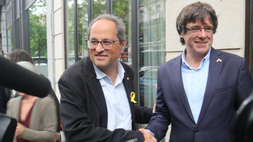 Torra i Puigdemont se saluden.