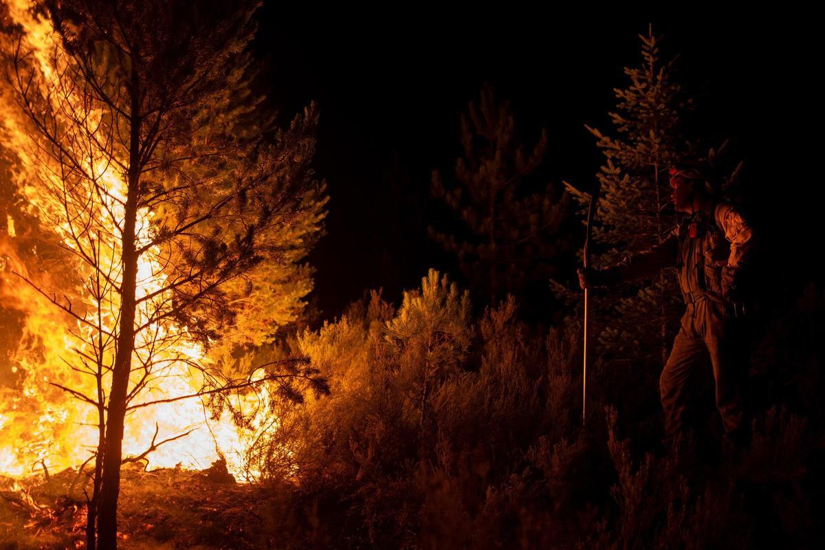 Un bombero forestal trata de extinguir un incendio.