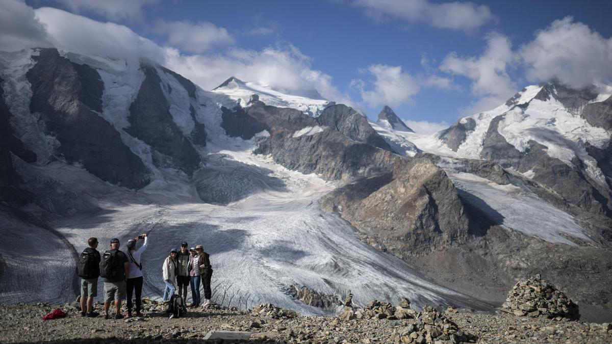 Varios turistas frente la montaña Bernina, en Suiza.