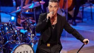 Archivo - 15 November 2022, Hamburg: British singer Robbie Williams and musicians of the New Philharmonic Orchestra Frankfurt perform on stage during a live concert in the Great Hall at the Elbphilharmonie. Williams gave a concert to celebrate 25 years of