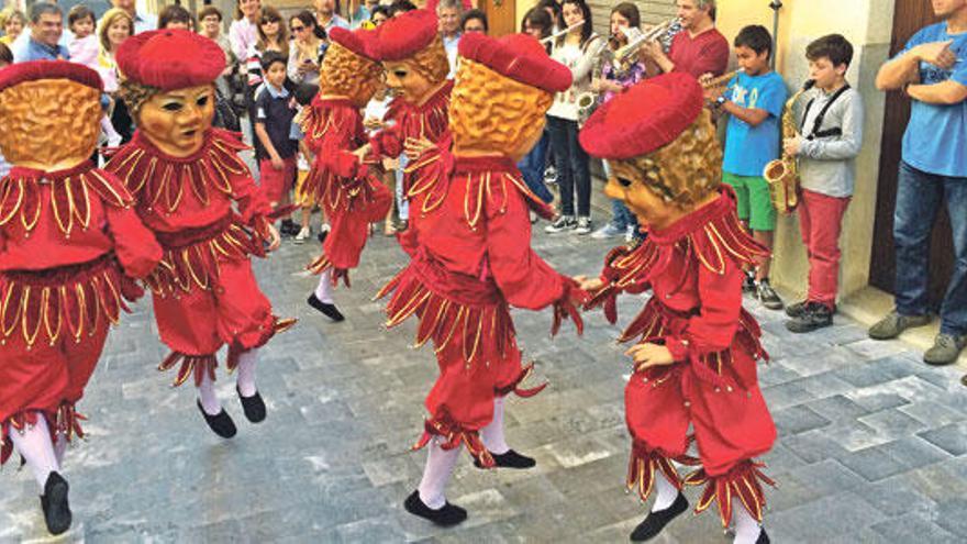 La calle den Figuera, engalanada con banderas, y los Nanets danzando ante la iglesia.