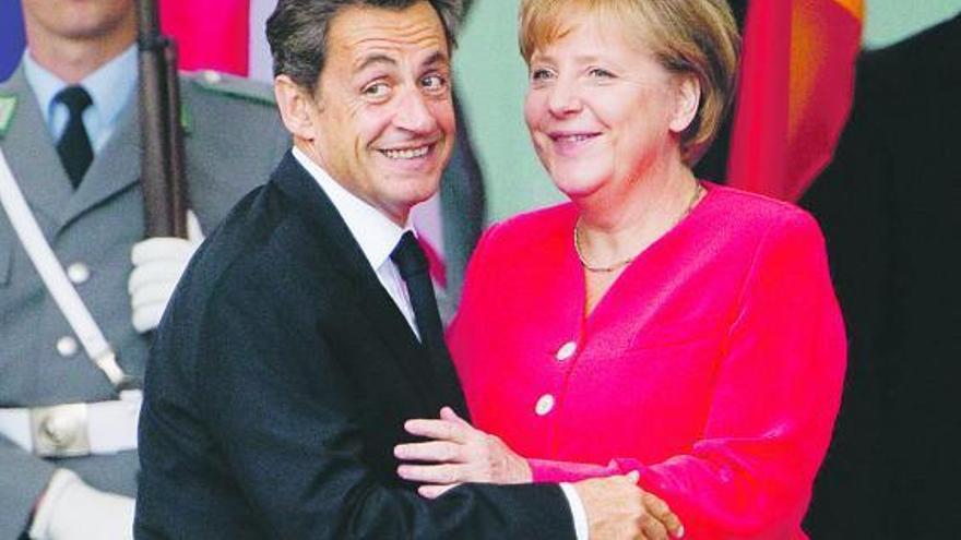 Nicolas Sarkozy y Angela Merkel, ayer, a la llegada del presidente francés a la cancillería alemana.