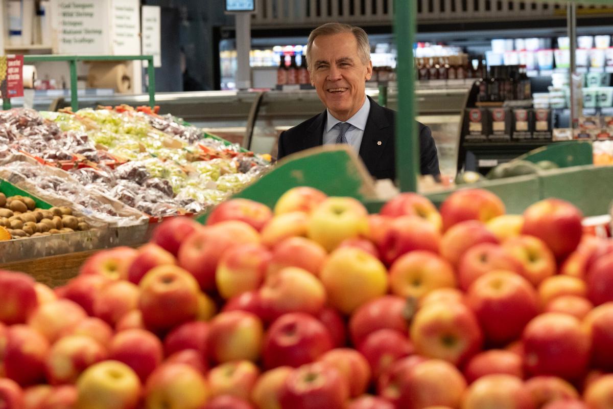 Canadian Prime Minister Mark Carney walks through an aisle to a podium for an event at a grocery store in Ottawa on Monday, Jan. 26, 2026. (Adrian Wyld/The Canadian Press via AP). MANDATORY CREDIT