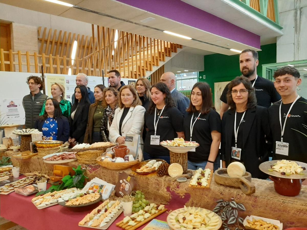 Participantes en el concurso y autoridades, ante una mesa de quesos asturianos