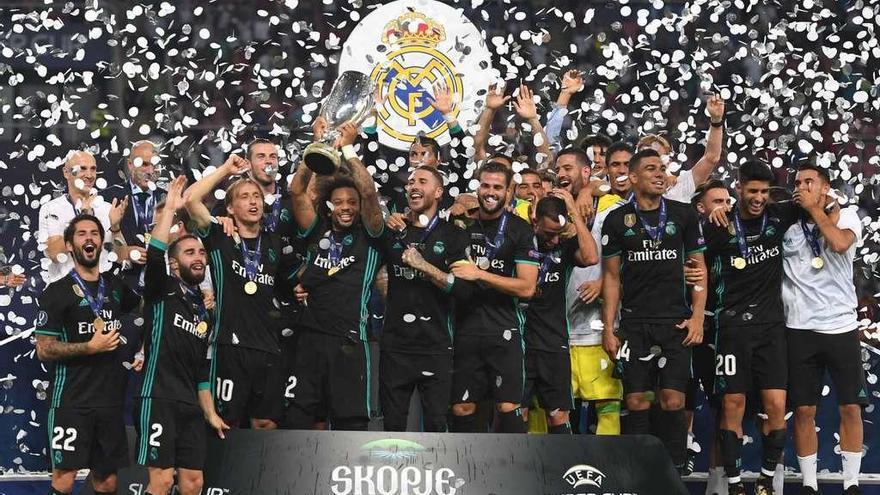 Los jugadores del Real Madrid levantan el trofeo de campeón.