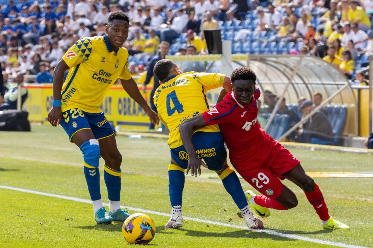 LAS PALMAS DE GRAN CANARIA (ESPAÑA), 12/01/2025.- El centrocampista de la UD Las Palmas Dario Essugo (i) y el defensa Alex Suárez (c) luchan por el balón con el centrocampista Coba da Costa (d); del Getafe durante el partido correspondiente a la jornada 19 de LaLiga disputado este domingo en el estadio de Gran Canaria. EFE/ Quique Curbelo
