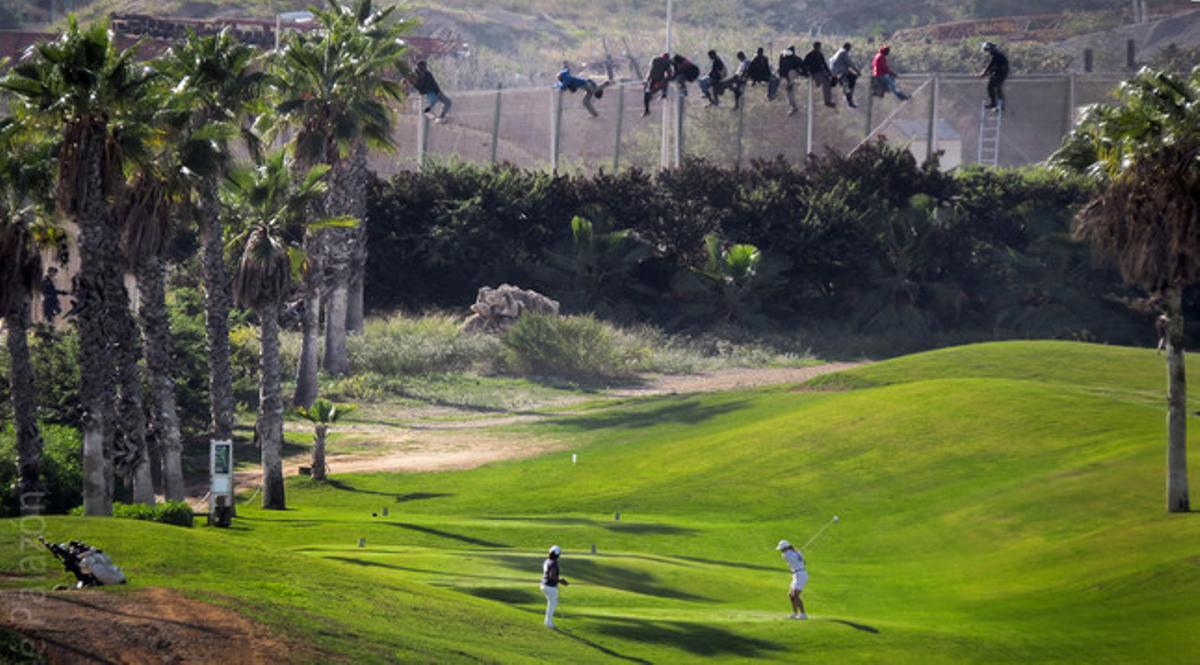 Un grup d’immigrants tracten de saltar la tanca de Melilla a tocar d’un camp on juguen dos golfistes. Un grup d’immigrants tracten de saltar la tanca de Melilla a tocar d’un camp on juguen dos golfistes.