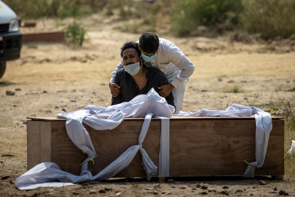 Un hombre consuela a un familiar cuyo padre ha muerto de coronavirus. Nueva Delhi, India, 16 de abril de 2021.