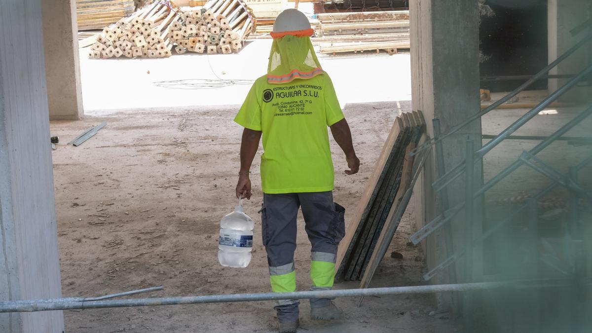 Un operario lleva una garrafa de agua fresca para repartir entre sus compañeros e hidratarse ante la ola de calor