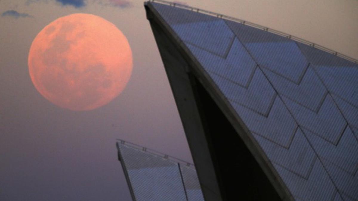 La luna, junto al edificio de la Ópera de Sídney (Australia), este domingo.