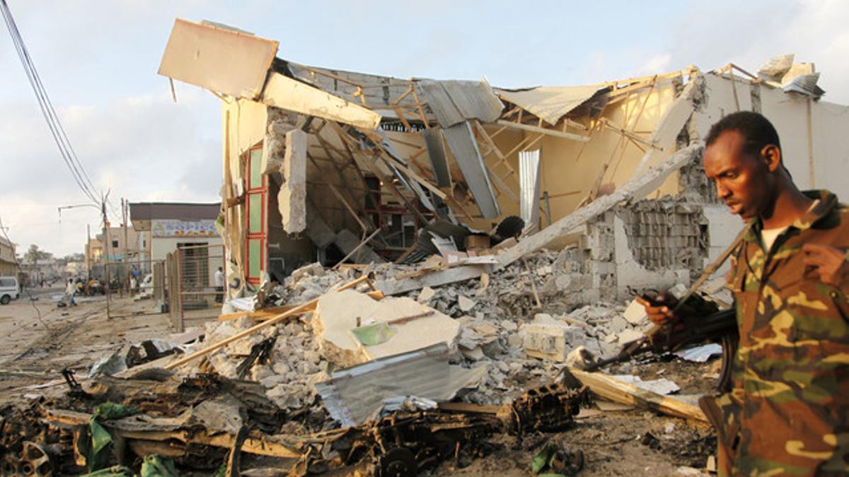 Un soldado camina frente a los destrozos en Somalia.