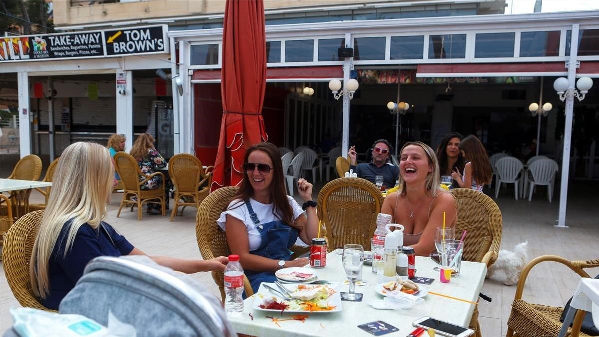 Jóvenes británicas residentes en Mallorca almuerzan en una terraza playera en Magaluf, el 16 de mayo del 2020