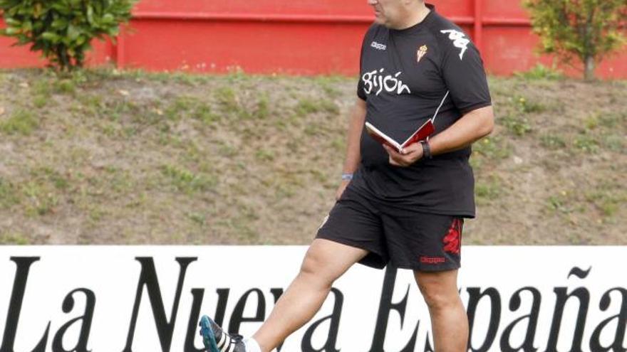 Sandoval, con su cuaderno de notas abierto, pisa un balón en el entrenamiento de ayer en Mareo.