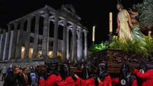 Una de las procesiones de la Semana Santa de Mérida, a su paso frente al Templo de Diana
